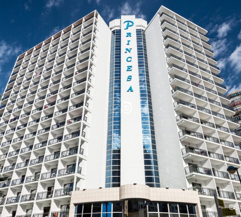 Hotel RH Princesa Tall hotel building with "Princesa" sign, balconies, and blue sky in the background.